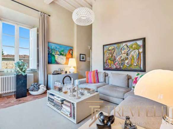 Элегантная гостиная в роскошной квартире с современным интерьером, яркими картинами и уютным освещением, идеально подходит для элитной недвижимости и высокого стиля жизни.