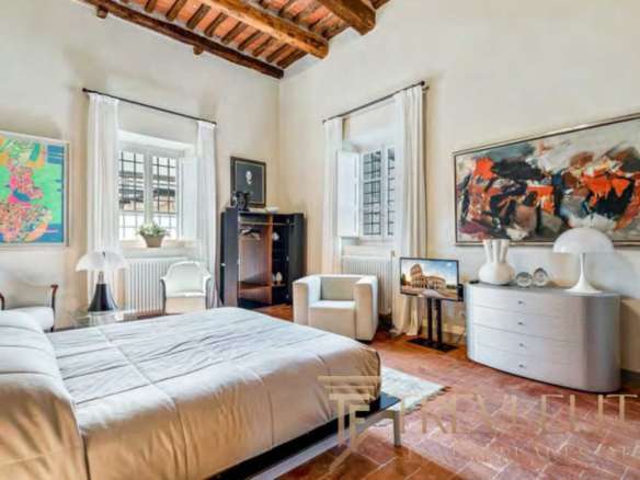 Элегантная спальня в роскошной итальянской недвижимости, светлый интерьер с живописными произведениями искусства и уютной атмосферой, идеальное жилье для ценителей эксклюзивных объектов.