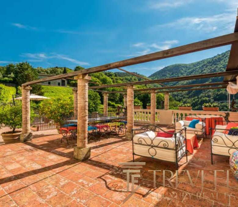 Роскошная терраса на открытом воздухе с видом на зелёные холмы и природу, стильная мебель, створённая для отдыха и наслаждения природой. Идеальное место для роскошных вечеров.