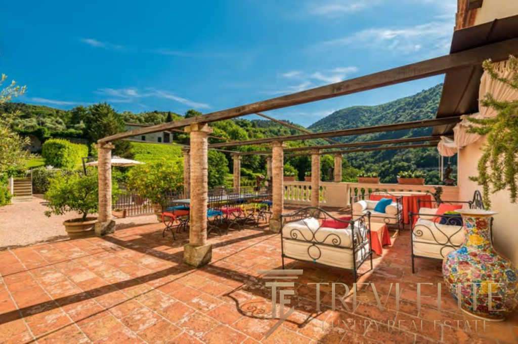 Роскошная терраса на открытом воздухе с видом на зелёные холмы и природу, стильная мебель, створённая для отдыха и наслаждения природой. Идеальное место для роскошных вечеров.