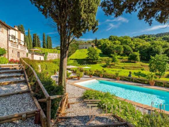 Уединенный роскошный дом с бассейном на фоне живописных зеленых холмов и деревьев, окруженный природой и итальянским пейзажем, идеальный для элитного отдыха и инвестиций.