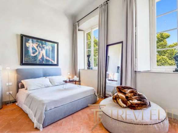 Современная спальня в стиле роскошного итальянского дома с большими окнами, светлыми стенами и уютной атмосферой.