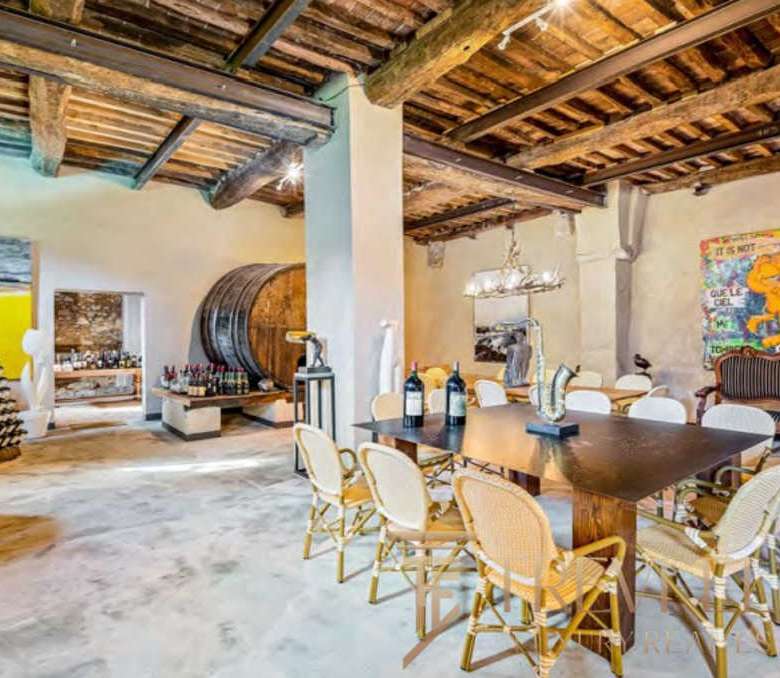 Современная роскошная гостиная с деревянным потолком и антикварной мебелью, идеальная для элитных мероприятий и отдыха, подчеркнутая искусством и уникальным дизайном интерьера.