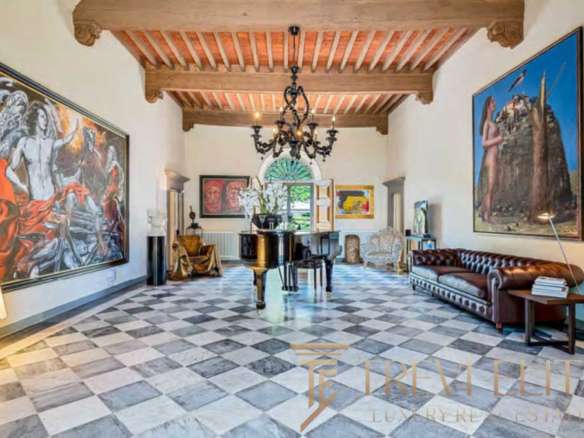 Роскошная зал с антикварным пианином, художественными картинами и уютной мебелью в стиле итальянской аутентичности, под деревянным потолком и элегантной люстрой.