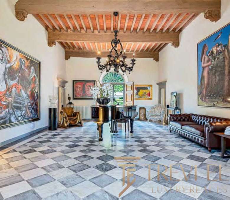 Роскошная зал с антикварным пианином, художественными картинами и уютной мебелью в стиле итальянской аутентичности, под деревянным потолком и элегантной люстрой.
