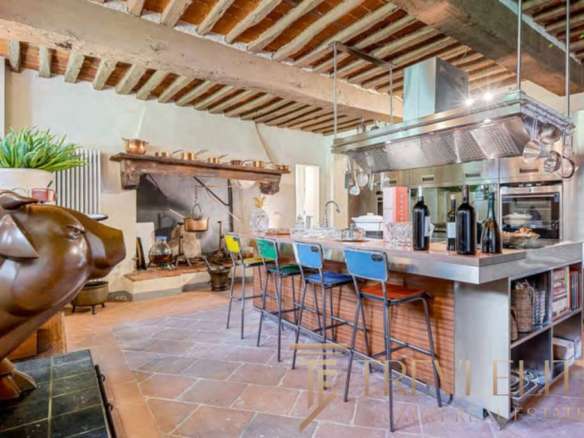 Роскошная кухня в стиле итальянского рустика с современными элементами, деревянным потолком и камином, идеальным для элитных резиденций и премиальных клиентов.