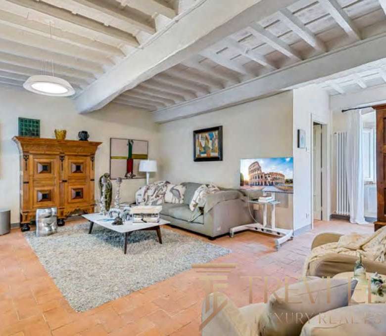 Элегантная гостиная с деревянной мебелью и уютной атмосферой в роскошном итальянском доме. Светлые стены и дизайнерские элементы создают гармоничное пространство для отдыха.