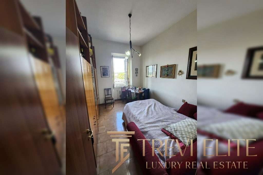 Уютная спальня в стильной квартире с яркими картинами на стенах и большой кроватью, просторной комнатой и светлым окном, создающим атмосферу комфорта и роскоши.