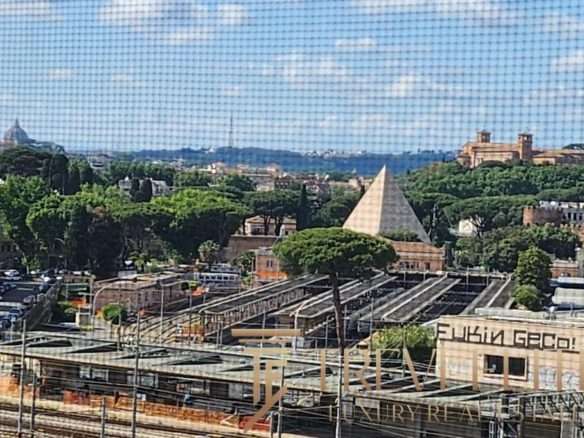 Вид на город с зелеными насаждениями и архитектурными памятниками, в центре фото база железнодорожных путей.