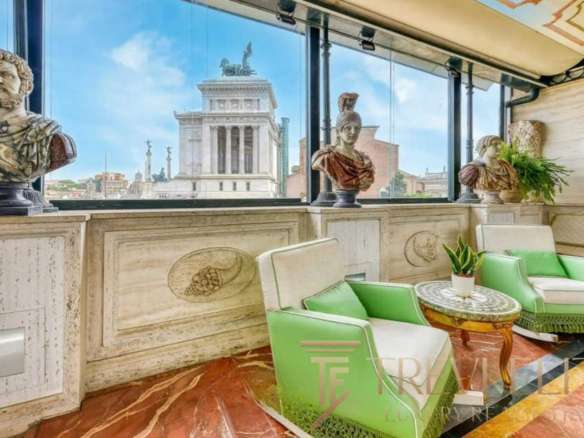 Бюсты древнегреческих и римских фигур, витрина с панорамным видом на Римские руины, уютная зона отдыха с мягкой мебелью и зелеными растениями в эксклюзивном агентстве недвижимости Треви Элит.