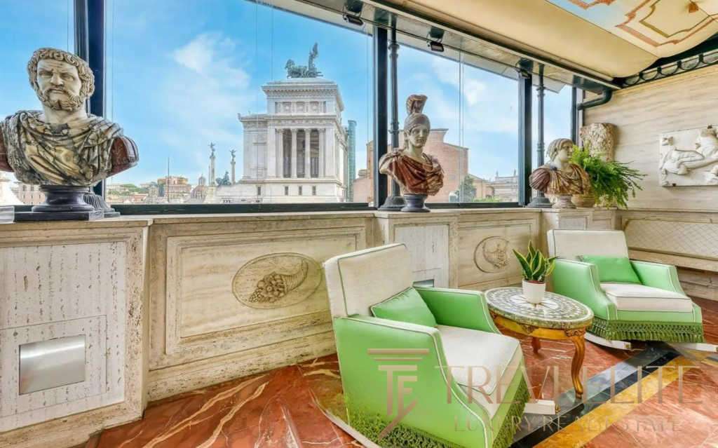 Бюсты древнегреческих и римских фигур, витрина с панорамным видом на Римские руины, уютная зона отдыха с мягкой мебелью и зелеными растениями в эксклюзивном агентстве недвижимости Треви Элит.