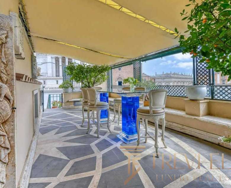 Уютная терраса на крыше с панорамным видом на город, украшенная зеленью и антикварной мебелью, идеально подходит для роскошных встреч и отдыха.