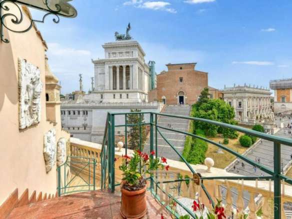 Вид на исторический центр Рима с балкона с цветами, вдохновляющий пейзаж старинных архитектурных памятников и городской панорамы.