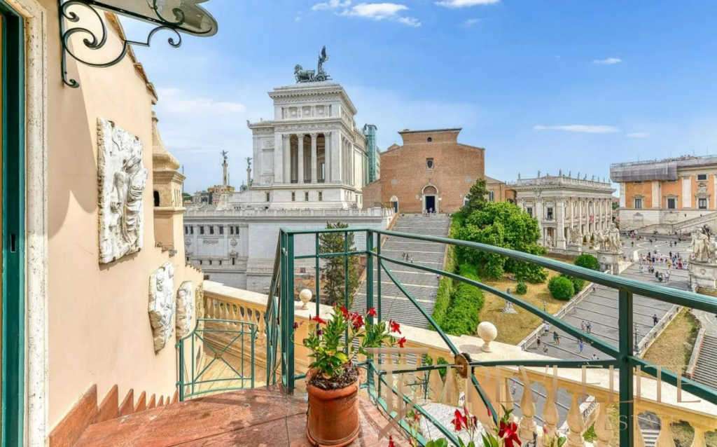 Вид на исторический центр Рима с балкона с цветами, вдохновляющий пейзаж старинных архитектурных памятников и городской панорамы.