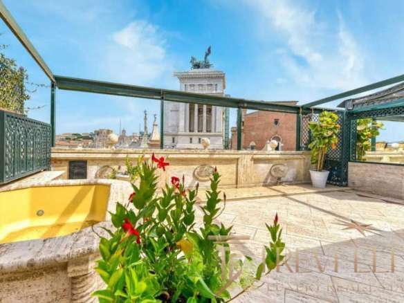 Элитная терраса на крыше здания с панорамным видом на исторический центр Рима, украшенная зеленью и цветами, идеально для отдыха и частных мероприятий.