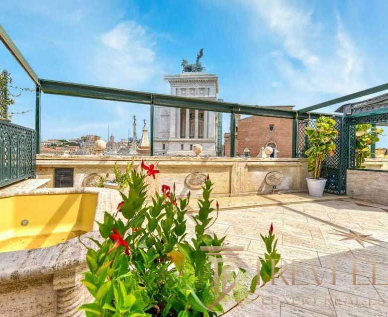Элитная терраса на крыше здания с панорамным видом на исторический центр Рима, украшенная зеленью и цветами, идеально для отдыха и частных мероприятий.