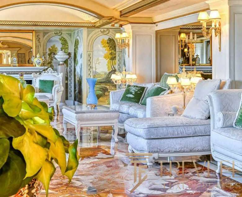 Роскошная гостиная с классической мебелью, художественным дизайном и мягким освещением, создающая уют и изысканность в престижных апартаментах Треви Элит.