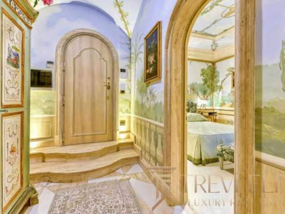 Элегантный вход с расписными стенами и декоративными элементами, ведущий в роскошную гостиную с классическим стилем и живописными пейзажами на стенах. haute couture interior design.