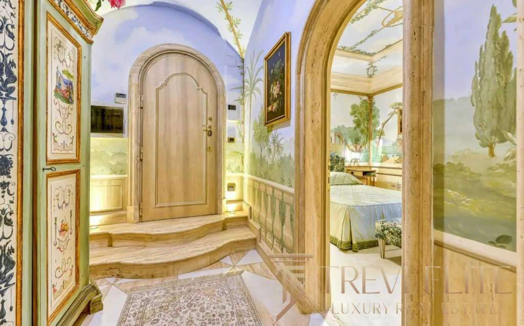 Элегантный вход с расписными стенами и декоративными элементами, ведущий в роскошную гостиную с классическим стилем и живописными пейзажами на стенах. haute couture interior design.