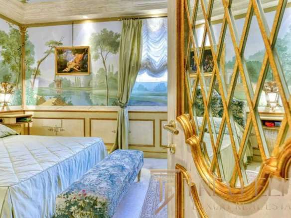 Роскошная спальня в элитной итальянской недвижимости с изысканным интерьером, лепниной и художественной росписью на стенах, создающая атмосферу уюта и статуса.