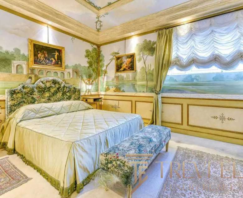 Роскошная спальня в итальянском стиле с классическими элементами, декоративным изголовьем и элегантными текстурами, создающими атмосферу уюта и изыска.