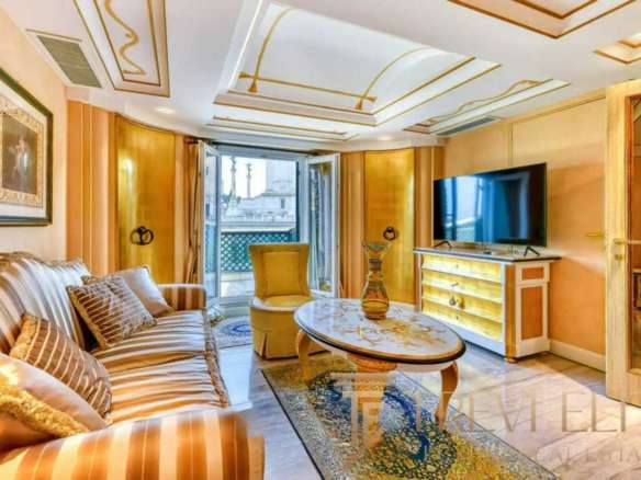 Элитная гостиная с уютным диваном, классическими картинами и балконным доступом, создающая ощущение роскоши и комфорта в эксклюзивных итальянских апартаментах.