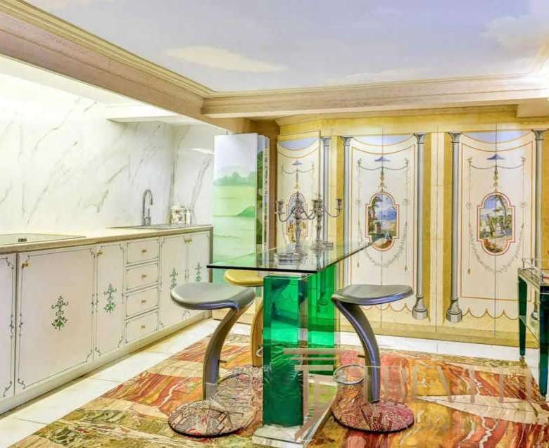 Элегантная кухня в классическом стиле с лепниной и декоративными панелями, светлым интерьером и уютной атмосферой, идеально подходящая для роскошной недвижимости высокого класса.