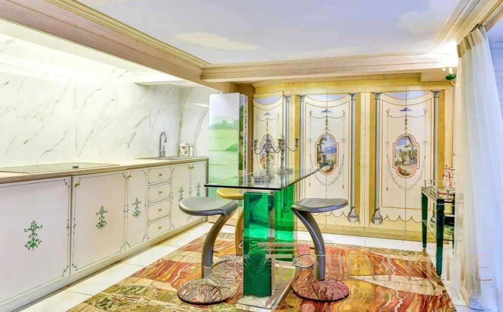 Элегантная кухня в классическом стиле с лепниной и декоративными панелями, светлым интерьером и уютной атмосферой, идеально подходящая для роскошной недвижимости высокого класса.