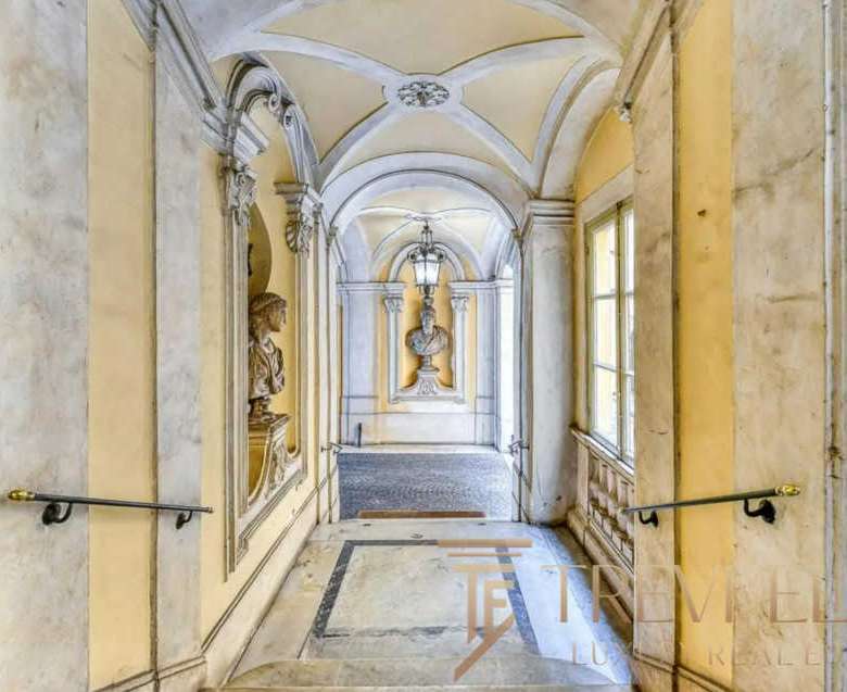 Элегантный коридор в historic villa с классическими архитектурными деталями и декоративными элементами внутри. Высокие окна и художественные лепнины создают атмосферу роскоши и уюта.