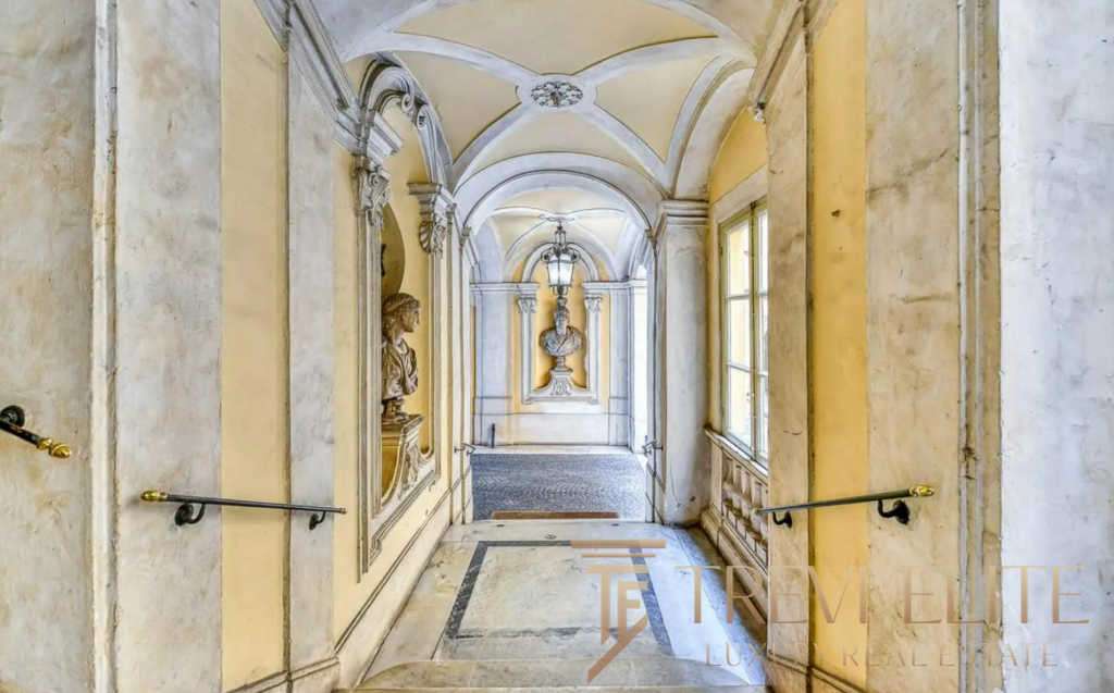 Элегантный коридор в historic villa с классическими архитектурными деталями и декоративными элементами внутри. Высокие окна и художественные лепнины создают атмосферу роскоши и уюта.