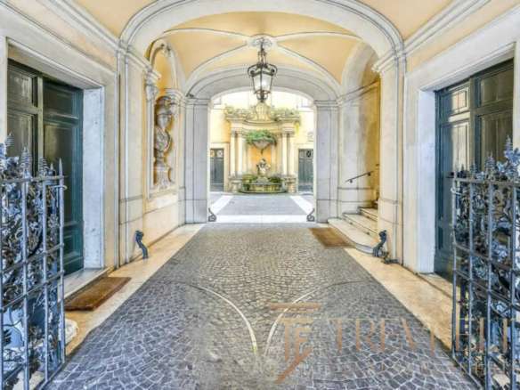 Роскошный вход в элитный итальянский дворец с коваными воротами и фонтаном на территории, подчеркнущий эксклюзивность недвижимости.