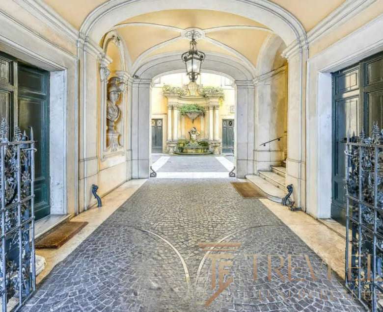 Роскошный вход в элитный итальянский дворец с коваными воротами и фонтаном на территории, подчеркнущий эксклюзивность недвижимости.