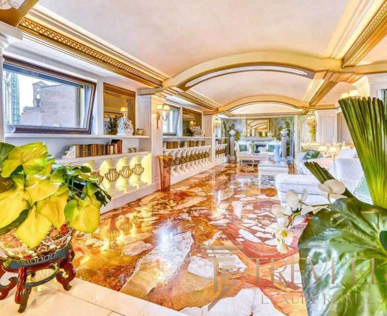 Роскошная гостиная с богатой отделкой, мраморным полом и ярким освещением, создающая атмосферу эксклюзивности и комфорта. Идеальное место для отдыха и встреч в элитной недвижимости.