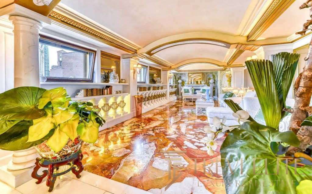 Роскошная гостиная с богатой отделкой, мраморным полом и ярким освещением, создающая атмосферу эксклюзивности и комфорта. Идеальное место для отдыха и встреч в элитной недвижимости.