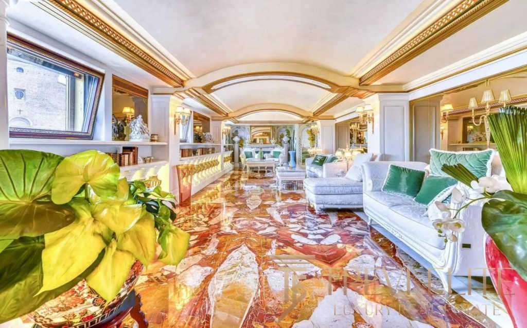 Роскошный интерьер салона с яркими декоративными элементами и высоким потолком в стиле классика. Великолепное освещение, уютный дизайн и элегантная мебель подчеркивают престиж агентства недвижимости Треви Элит.