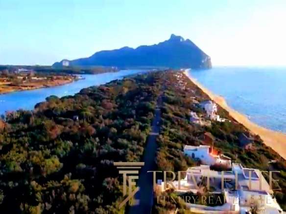 Уединенный берег с панорамным видом на море и горы, роскошные виллы и элегантный пейзаж, идеальное место для роскошной недвижимости на побережье Италии.