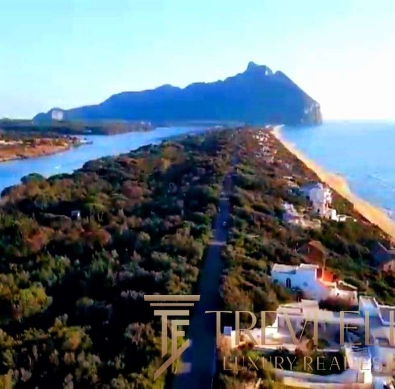 Уединенный берег с панорамным видом на море и горы, роскошные виллы и элегантный пейзаж, идеальное место для роскошной недвижимости на побережье Италии.