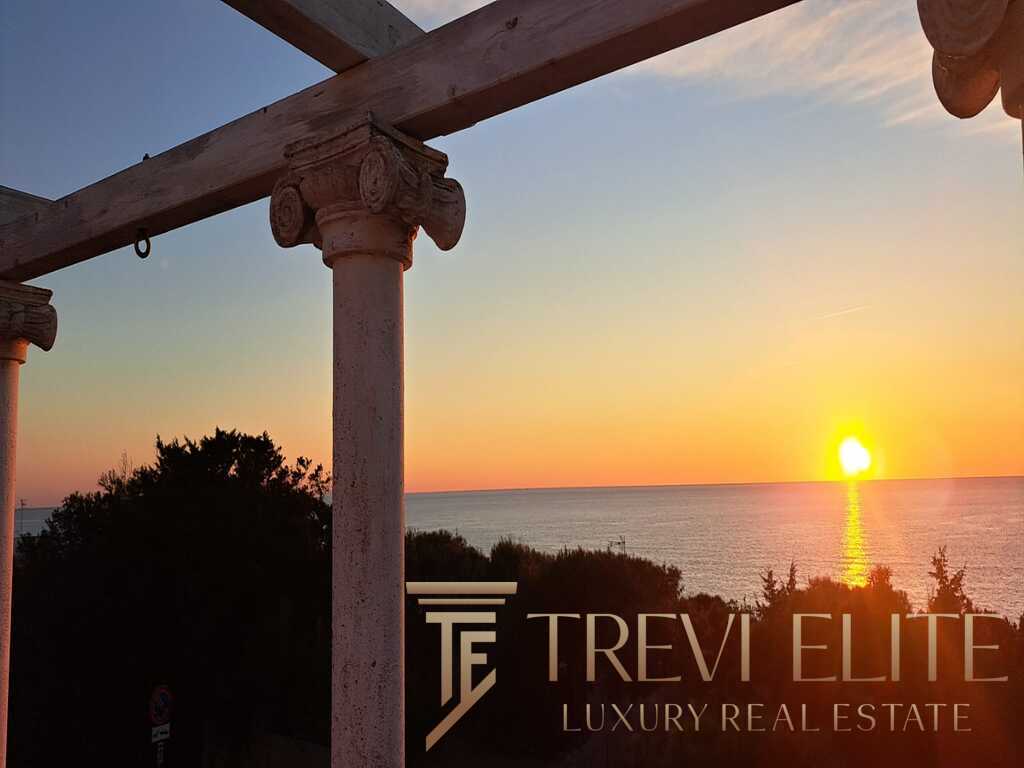 Виды живописного пляжа и закат на побережье с старинными колоннами и архитектурными элементами, создающими атмосферу итальянского шика и эксклюзивности. Идеальный кадр для агентства недвижимости премиум-класса.