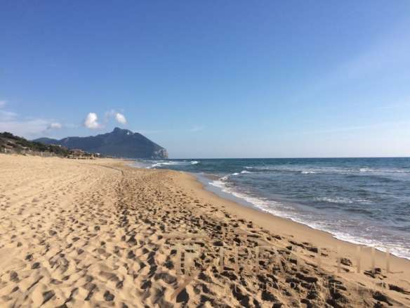 Незагрязненный пляж с золотым песком и видом на горы и море. Идеальное место для отдыха и элитной недвижимости в Италии.