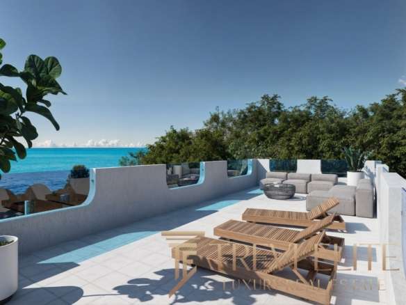Роскошная терраса у моря с видом на океан, украшенная стильной мебелью и шезлонгами, окружена зеленью, идеально подходит для отдыха и наслаждения красивыми панорамами.