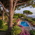 Роскошный бассейн на фоне живописных зеленых насаждений и моря, окруженный цветущими кустарниками и пышной растительностью, создает атмосферу уединения и великолепия.