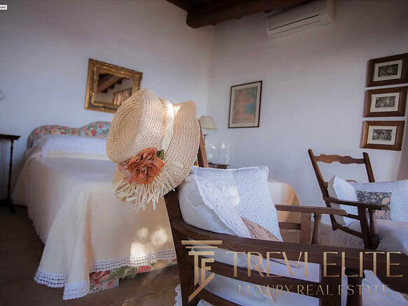 Уютная спальня с мягким светом, деревянной мебелью и романтическим декором в стиле тосканской винтажной эстетики, идеальное место для отдыха в высококлассной недвижимости.