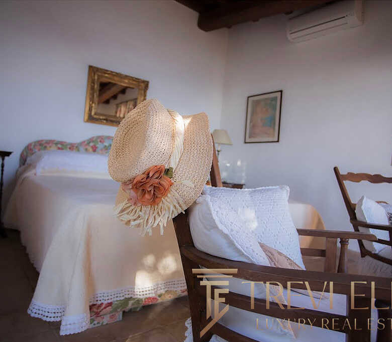 Уютная спальня с мягким светом, деревянной мебелью и романтическим декором в стиле тосканской винтажной эстетики, идеальное место для отдыха в высококлассной недвижимости.