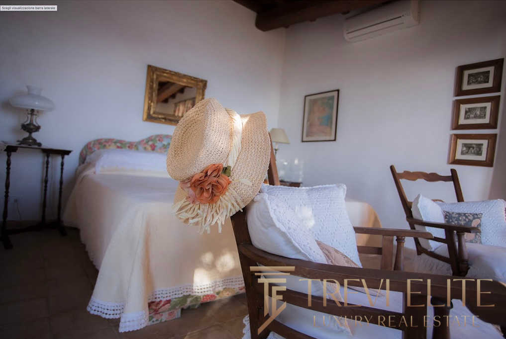 Уютная спальня с мягким светом, деревянной мебелью и романтическим декором в стиле тосканской винтажной эстетики, идеальное место для отдыха в высококлассной недвижимости.