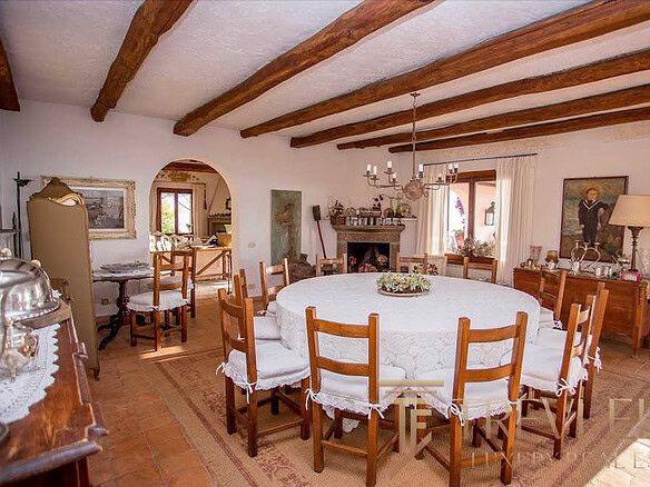 Высококлассная итальянская загородная вилла с традиционной мебелью, уютной гостиной и панорамными окнами, создающими теплую атмосферу уюта и роскоши для комфортного отдыха.