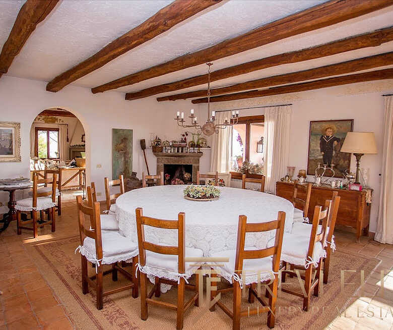 Высококлассная итальянская загородная вилла с традиционной мебелью, уютной гостиной и панорамными окнами, создающими теплую атмосферу уюта и роскоши для комфортного отдыха.