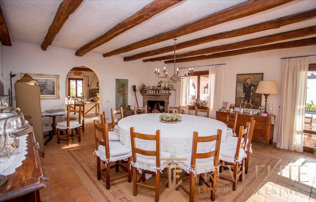 Высококлассная итальянская загородная вилла с традиционной мебелью, уютной гостиной и панорамными окнами, создающими теплую атмосферу уюта и роскоши для комфортного отдыха.