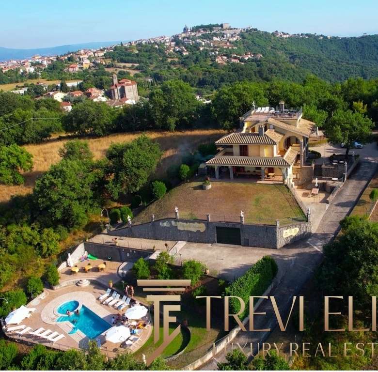 Роскошный загородный дом с бассейном и ухоженным садом на зеленом холме в живописном районе, предлагающий уединение и комфорт для ценителей элитной недвижимости.