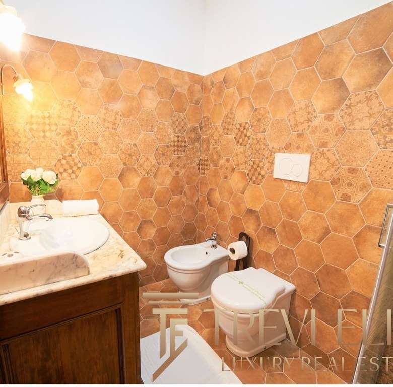 Изображение современного дизайнерского санузла с терраццо плиткой на стенах, деревянной мебелью, утварью и стильным освещением. Идеальное сочетание роскоши и комфорта в элитной недвижимости.