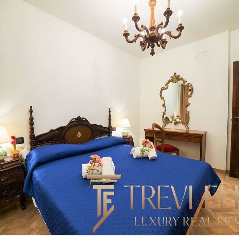 Элегантная спальня в классическом стиле с темной деревянной мебелью и голубым постельным бельем для престижных роскошных апартаментов.